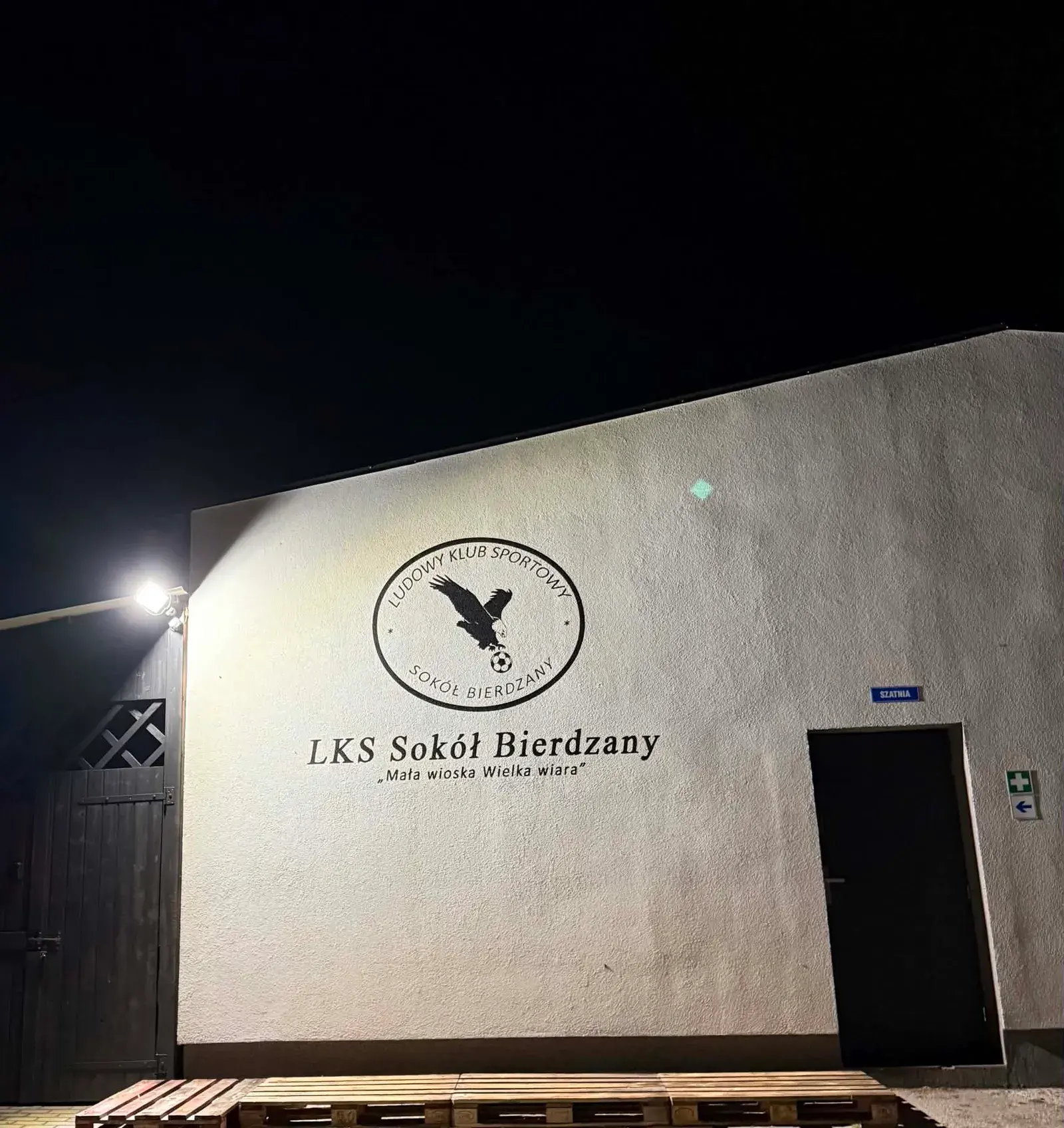 Elewacja budynku klubowego LKS Sokół Bierdzany z naniesionym logotypem i nazwą klubu — zdjęcie 1 z 2